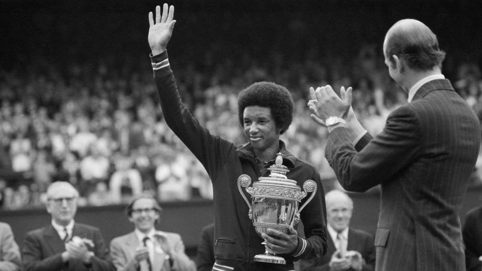 Arthur Ashe waves to the crowd after winning Wimbledon in 1975. - Mirrorpix/Getty Images
