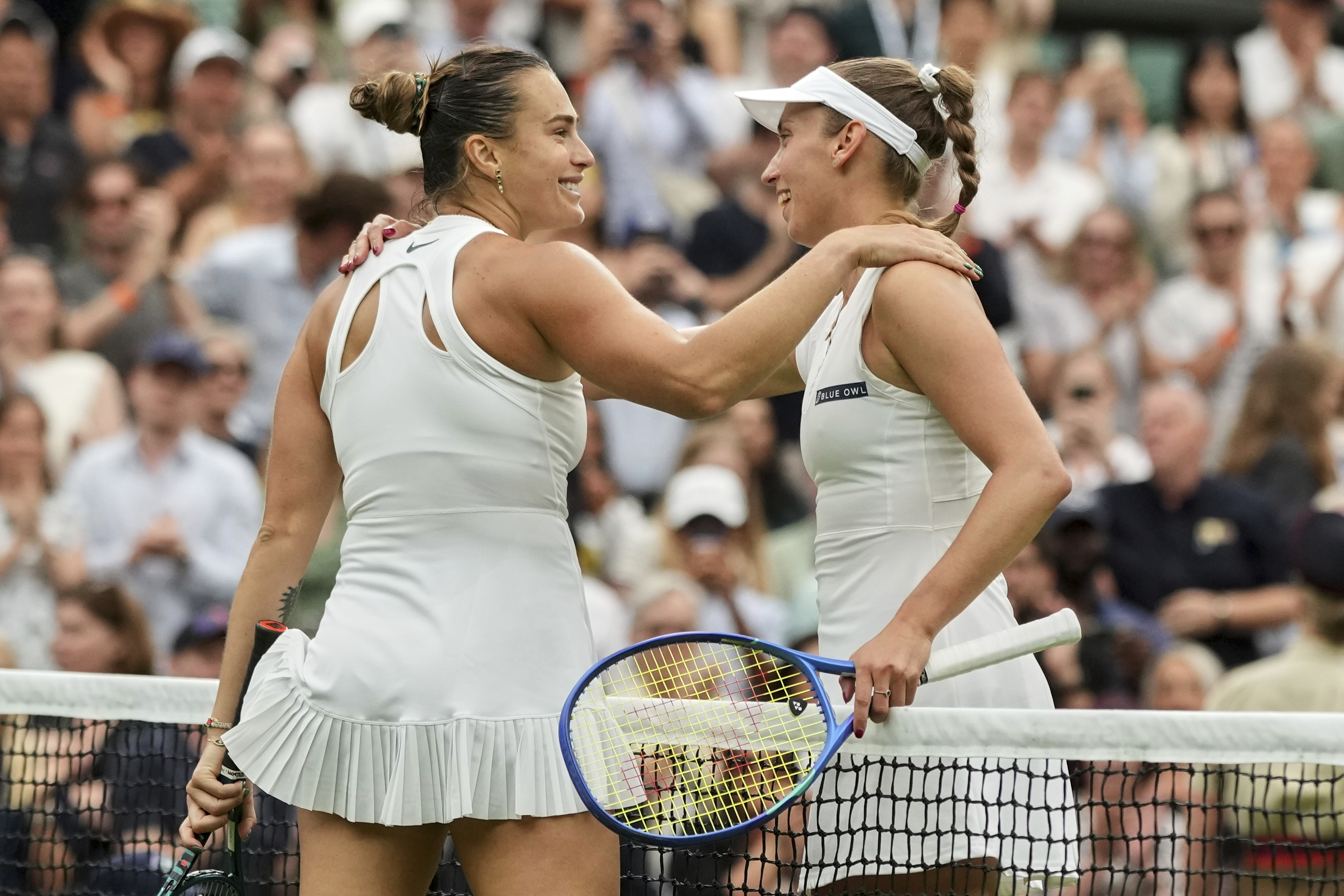Aryna Sabalenka of Belarus, left, greets Belgium's Elise Mertens after beating her in a fourth round women's singles match at the Wimbledon Tennis Championships in London, Sunday, July 6, 2025. (AP Photo/Alastair Grant)