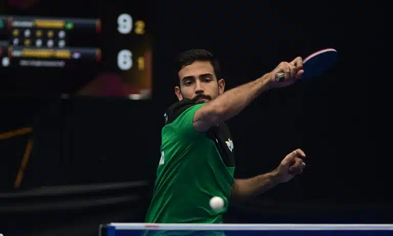 Na imagem, Guilherme Teodoro dando um golpe de forehand na bolinha com sua raquete.