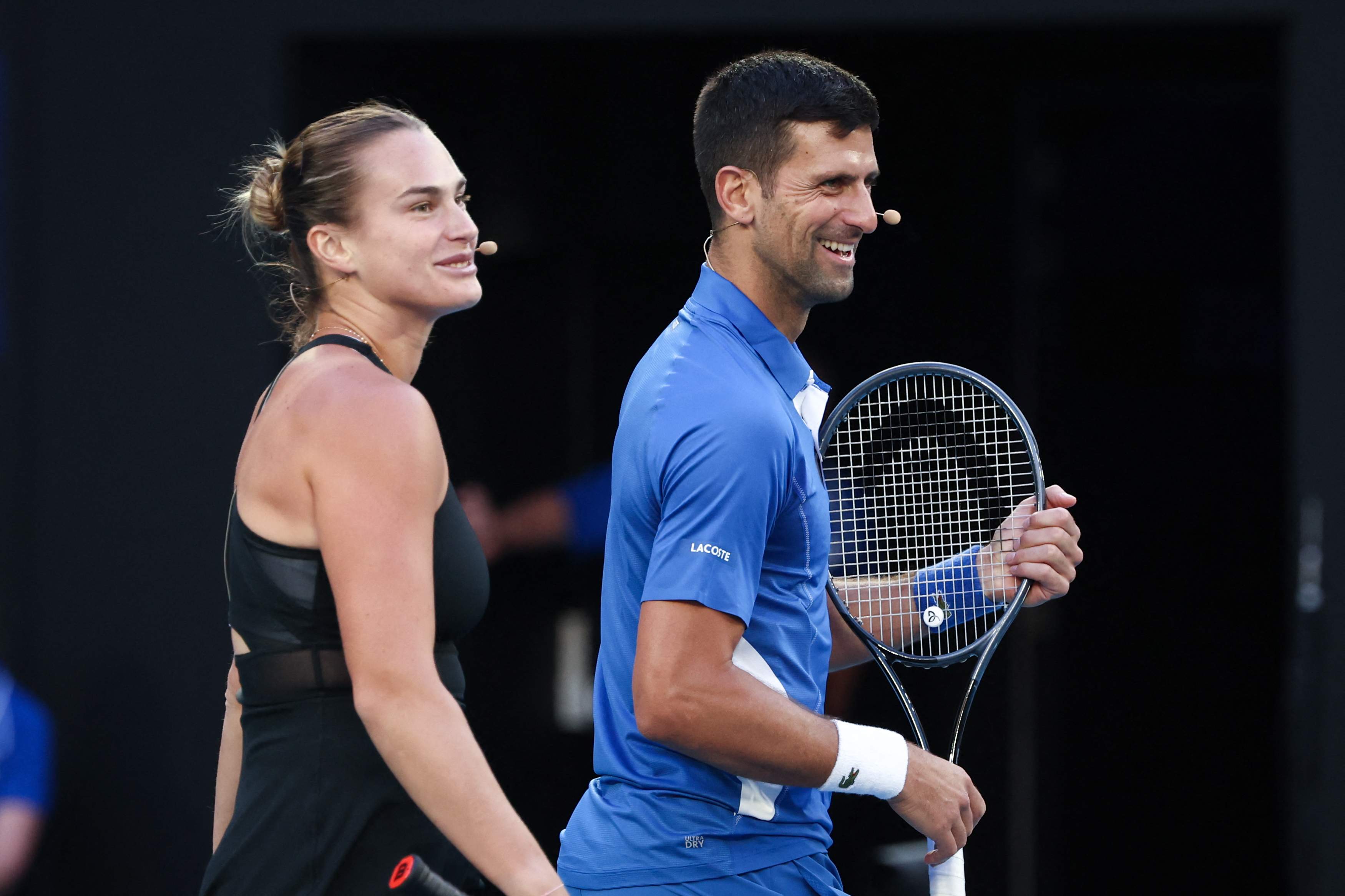 Aryna Sabalenka from Belarus and Serbia's Novak Djokovic play mixed-doubles together during a charity event on Rod Laver Arena in Melbourne on January 11, 2024 ahead of the Australian Open tennis championship starting on January 14. (Photo by DAVID GRAY / AFP via Getty Images) / -- IMAGE RESTRICTED TO EDITORIAL USE - STRICTLY NO COMMERCIAL USE --