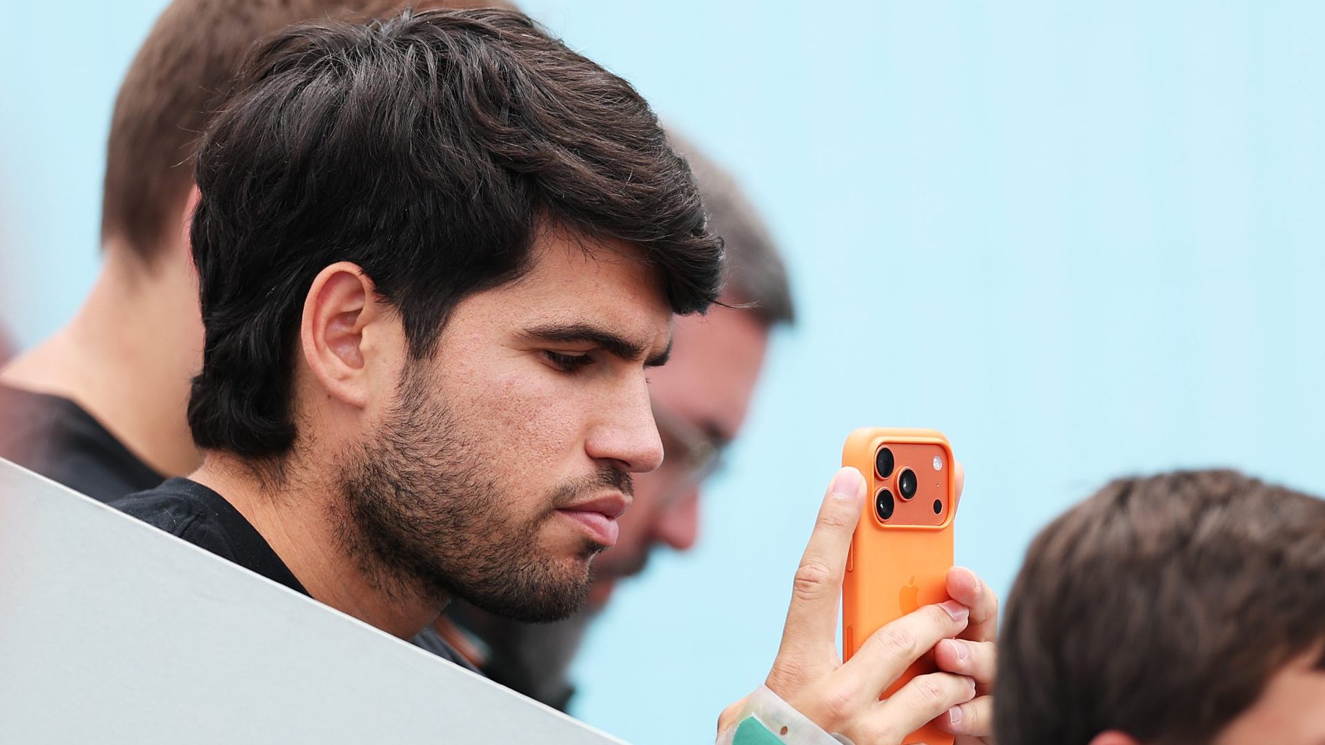 An injured Carlos Alcaraz of Spain watches his bother Jaime Alcaraz of Spain while he plays Poi Mas Tabuena of Spain in the Mutua Madrid 