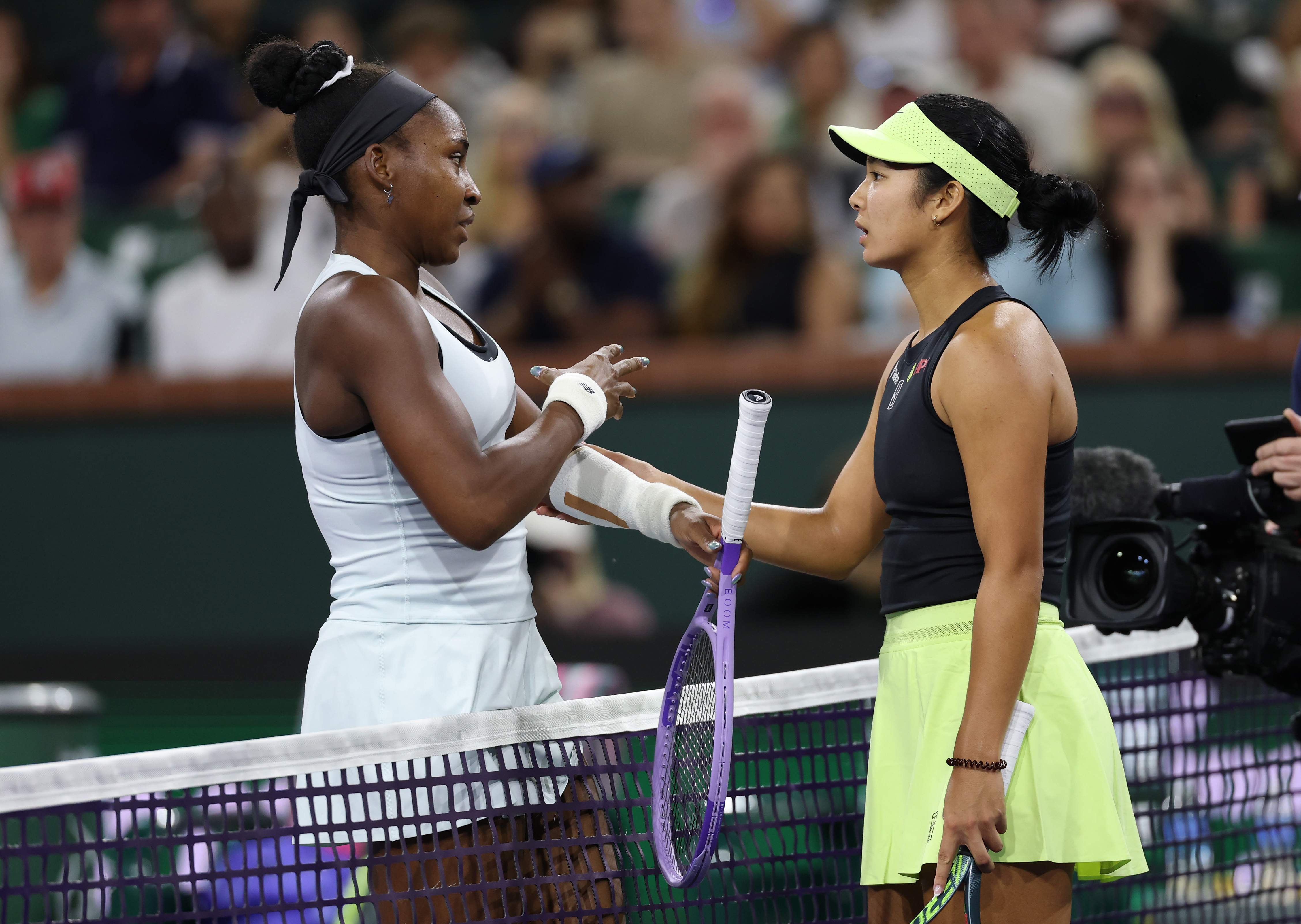 INDIAN WELLS, CALIFORNIA - MARCH 08: Coco Gauff of the United States at the net with Alexandra Eala of the Phiippines after she has retired with an arm injury from their third round match of the BNP Paribas Open at Indian Wells Tennis Garden on March 08, 2026 in Indian Wells, California. (Photo by Clive Brunskill/Getty Images)